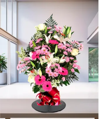 Mazzo funebre di gigli e gerbere nei toni rosa